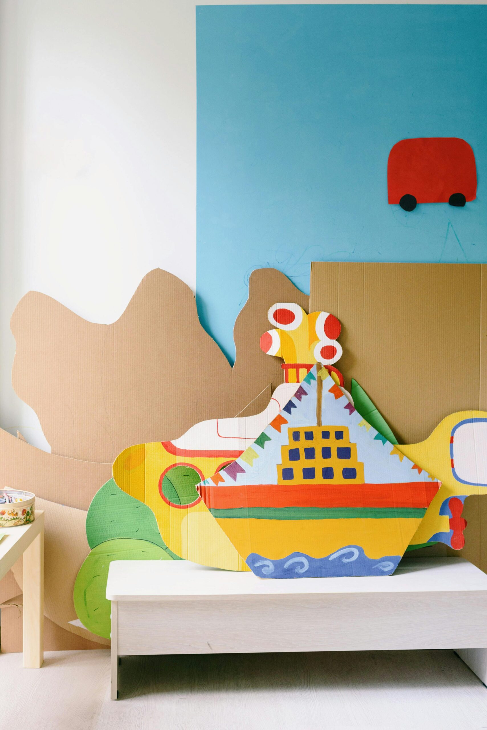 A vibrant paper craft ship in a playful children's room with colorful decorations.